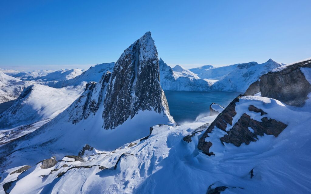 Snow-covered mountains dominate a crisp, blue landscape.